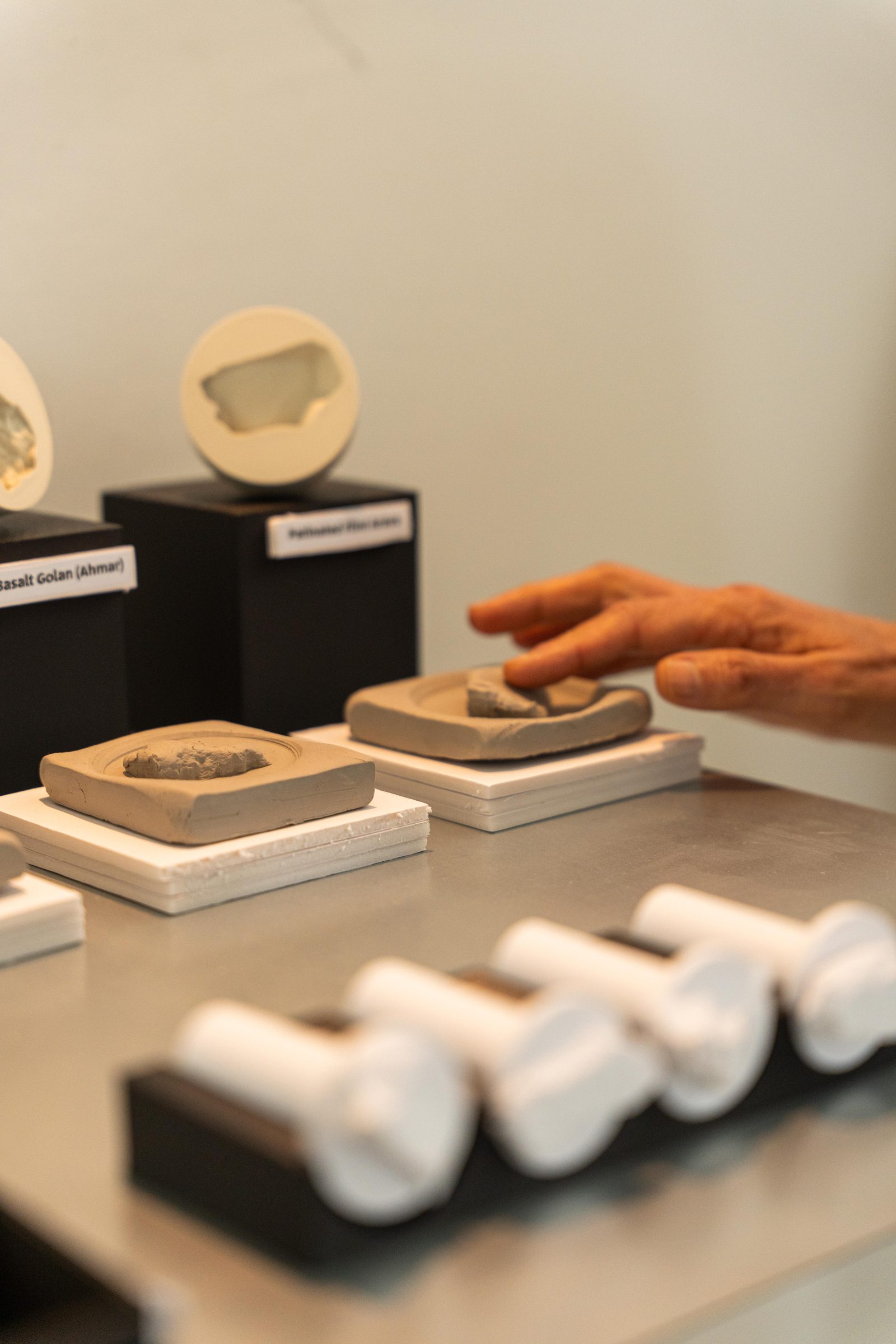 Finger pressing a stamp into clay